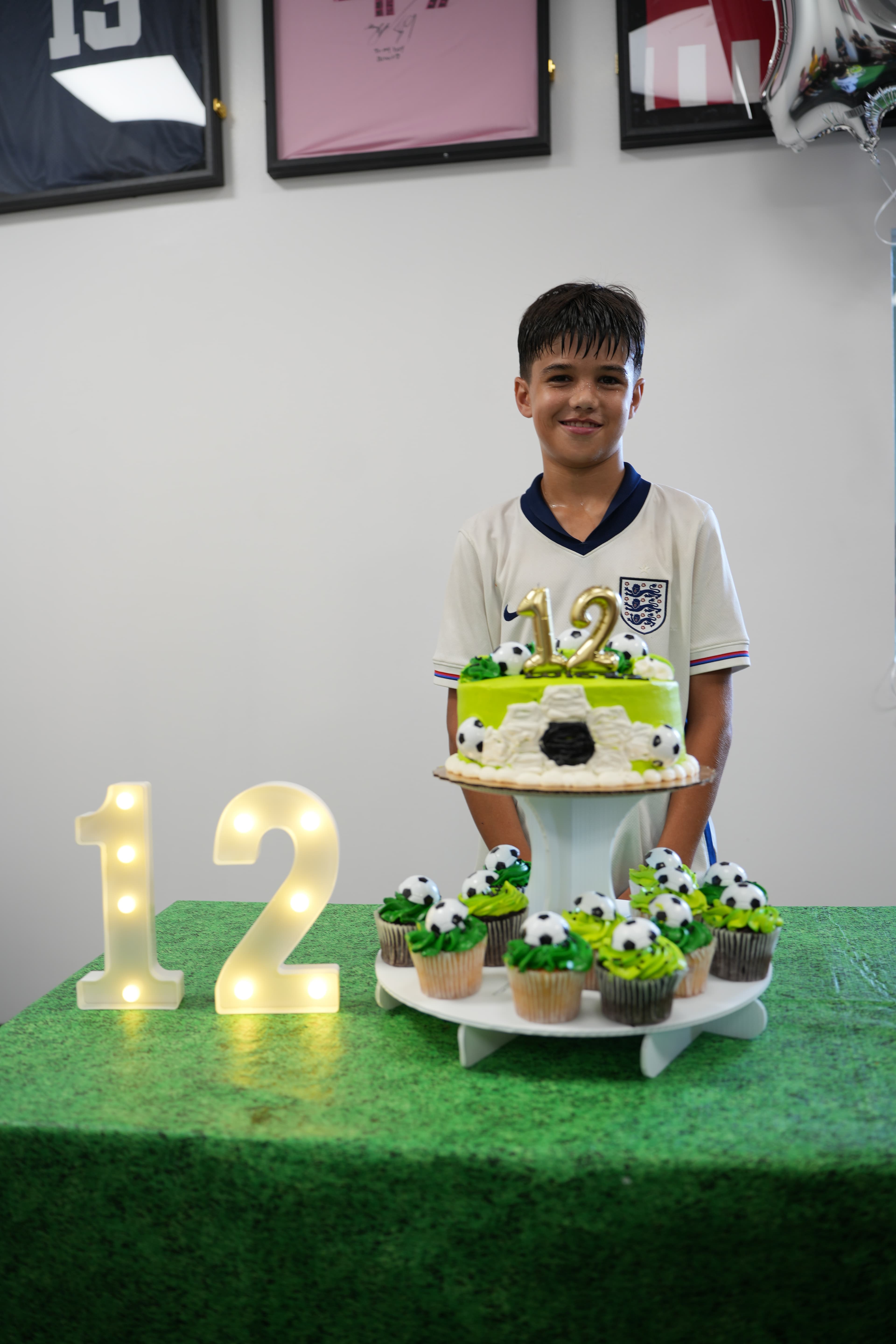 Birthday kid holding a soccer-themed cake at SoFlo Soccer